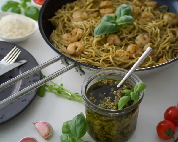 Pesto Genovese Zutaten: Pasta mit Garnelen, frisches Basilikum, Knoblauch, Kirschtomaten und geriebener Parmesan.