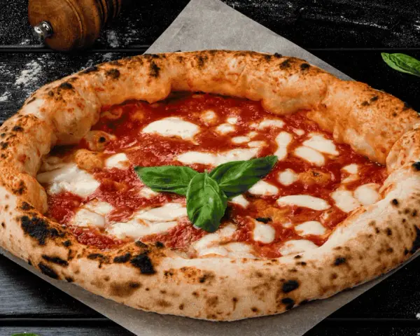 Eine authentische Pizza aus Italien, mit knusprigem Rand, geschmolzenem Mozzarella und frischem Basilikum.
