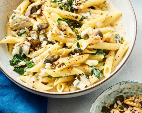 Bandnudeln italienisch mit Spinat, Gorgonzola und Kernen in cremiger Sauce. Ein Genuss für Feinschmecker.