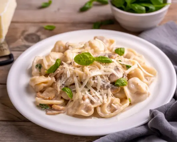 Cremige Tortellini Funghi mit frischem Basilikum und Parmesan. Ein Genuss für jeden Pasta-Liebhaber.