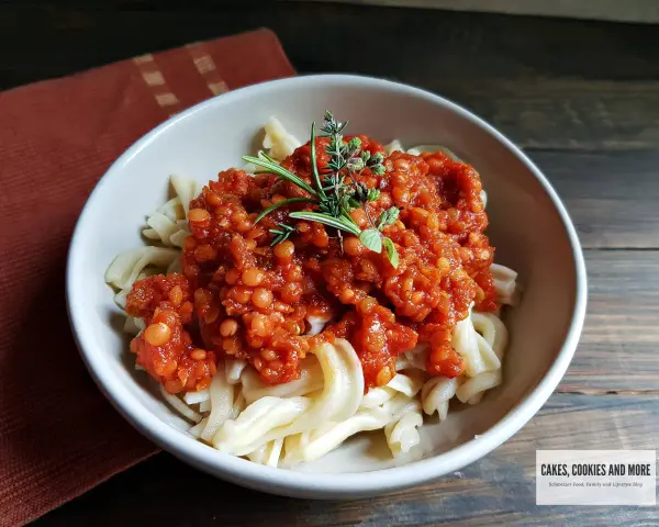 Herzhafte Linsen Bolognese auf Bandnudeln, garniert mit frischen Kräutern. Ein köstliches vegetarisches Gericht.