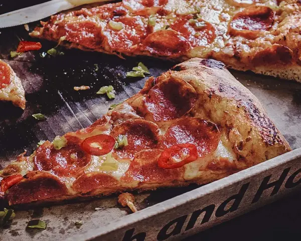 Saftige Peperoni-Pizza mit scharfen Chilis und grünen Paprikastückchen. Was ist Peperoni? Das sind die roten Scheiben auf der Pizza!