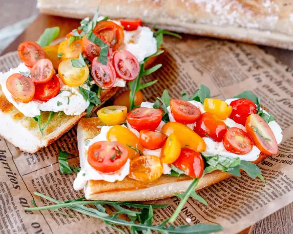 Burrata-Bruschetta mit bunten Tomaten und Rucola – ein einfaches Rezept für den Sommer.