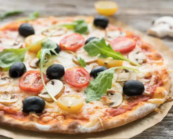 Pizza mit original italienischem pizzateig wenig hefe, belegt mit Tomaten, Oliven und Pilzen.