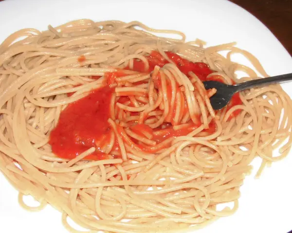 Spaghetti mit bester Tomatensauce, die mit einer Gabel aufgewirbelt wird. Ein einfaches, aber köstliches Gericht.