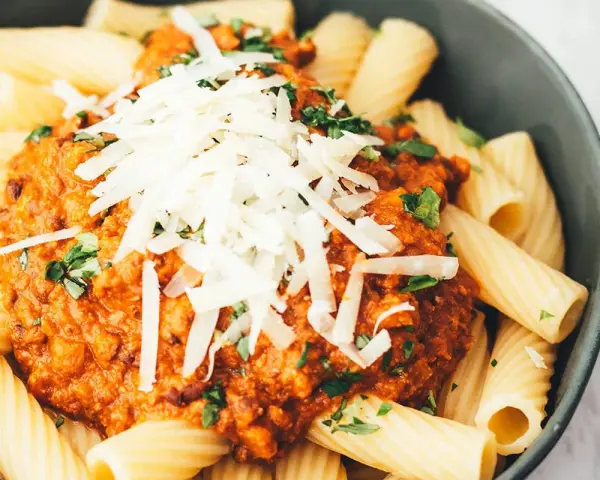 Ein Teller Rigatoni mit Bolognese und Parmesan. Sind Nudeln leicht verdaulich? Diese hier sehen köstlich aus!