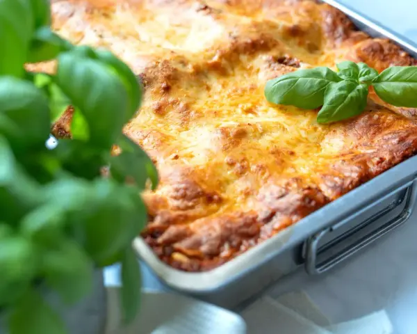 Frisch gebackene Lasagne im Ofen, goldbraun überbacken, mit frischem Basilikum garniert. Ein perfektes Lasagne Rezept für Genießer.