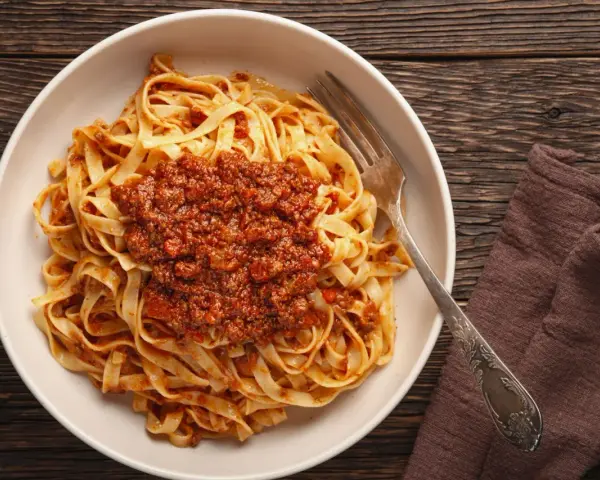 Teller mit Tagliatelle und herzhafter Bolognese-Sauce, bereit zum Genießen. Ein klassisches bolognese rezept.