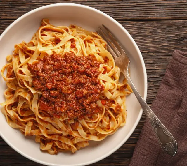 Teller mit Tagliatelle und herzhafter Bolognese-Sauce, bereit zum Genießen. Ein klassisches bolognese rezept.