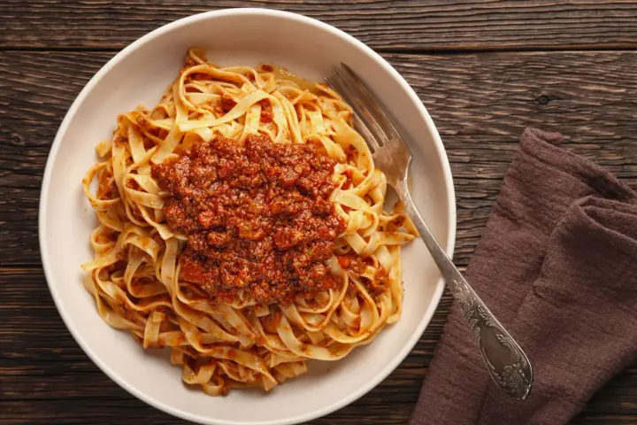Teller mit Tagliatelle und herzhafter Bolognese-Sauce, bereit zum Genießen. Ein klassisches bolognese rezept.
