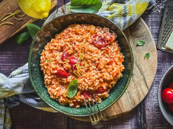 Cremiges Tomaten-Risotto, ein einfaches und köstliches Risotto Rezept, garniert mit Basilikum und Zitronenzeste.