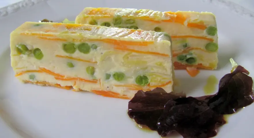 Zwei Scheiben Gemüseterrine mit Erbsen und Karotten, eine köstliche Vorspeise. Perfekt für Terrinen Rezepte.