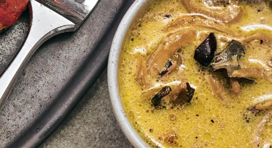 Cremige funghi sauce mit Pilzstücken in einer Schüssel, daneben eine Gabel.