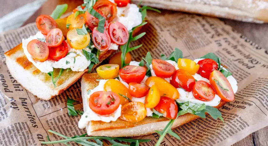 Burrata-Bruschetta mit bunten Tomaten und Rucola – ein einfaches Rezept für den Sommer.