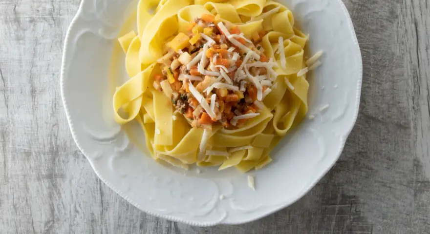 Pappardelle mit einer herzhaften Gemüsesauce und geriebenem Käse. Ein einfaches und leckeres Pappardelle Rezept.