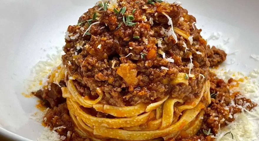 Ein Turm aus Tagliatelle, bedeckt mit einer reichhaltigen, fleischigen Sauce. Das ist, was bolognese bedeutet: ein Klassiker der italienischen Küche.