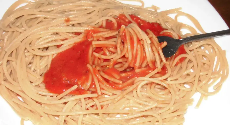 Spaghetti mit bester Tomatensauce, die mit einer Gabel aufgewirbelt wird. Ein einfaches, aber köstliches Gericht.