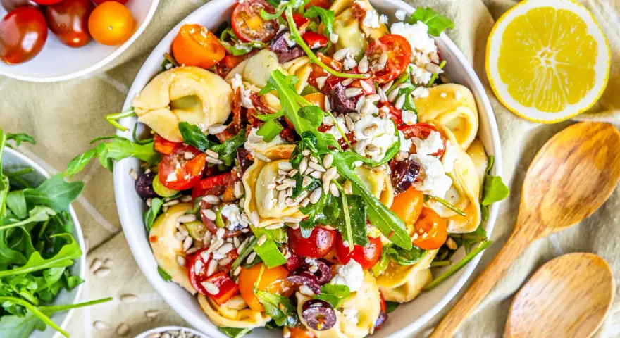 Ein bunter, sommerlicher Tortellinisalat mit Kirschtomaten, Rucola, Oliven und Feta. Perfekt für heiße Tage!
