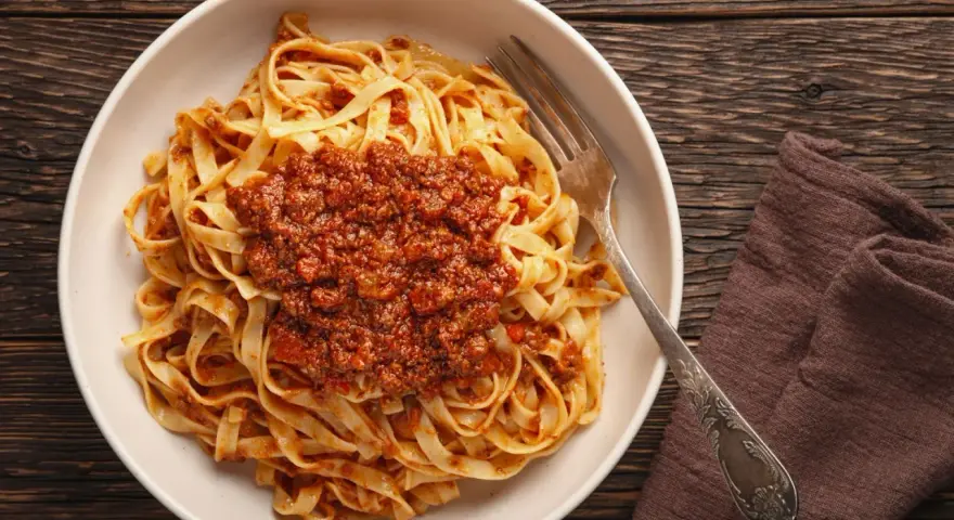 Teller mit Tagliatelle und herzhafter Bolognese-Sauce, bereit zum Genießen. Ein klassisches bolognese rezept.