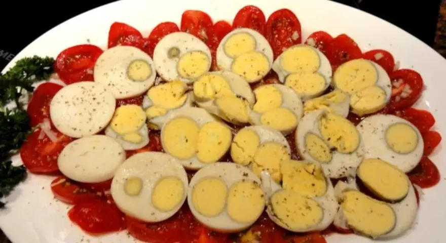Tomaten und hartgekochte Eier, garniert mit Petersilie. Eine einfache, aber leckere Tomaten-Frittata-Beilage.