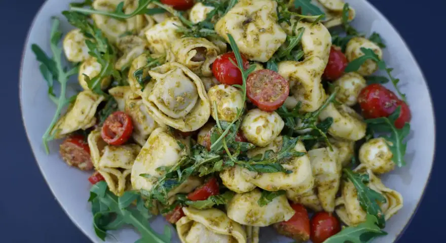 Tortellini Salat mit Rucola, Kirschtomaten und Mozzarella-Kugeln, alles in Pesto geschwenkt. Ein leichter Genuss!