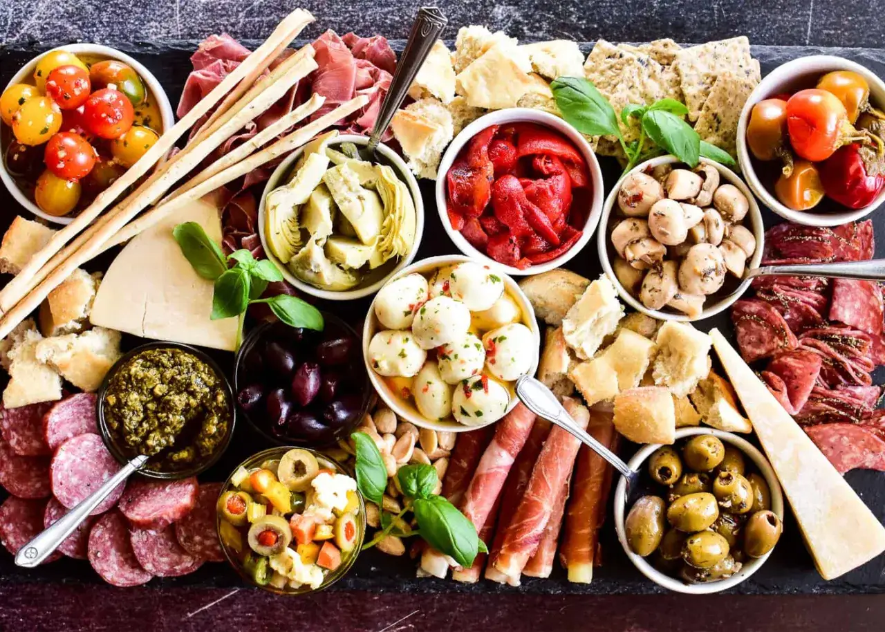 Ein Fest für die Sinne: italienisches Fingerfood kalt mit Salami, Prosciutto, Mozzarella-Bällchen, Oliven, Artischocken und Grissini. Perfekt für jede Party!