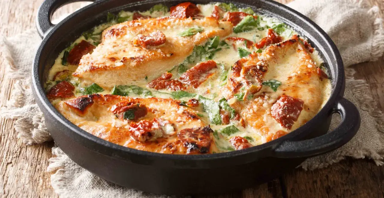 H&auml;hnchenbrust in cremiger basilikum sahne sauce mit getrockneten Tomaten und Spinat, bestreut mit Parmesan.