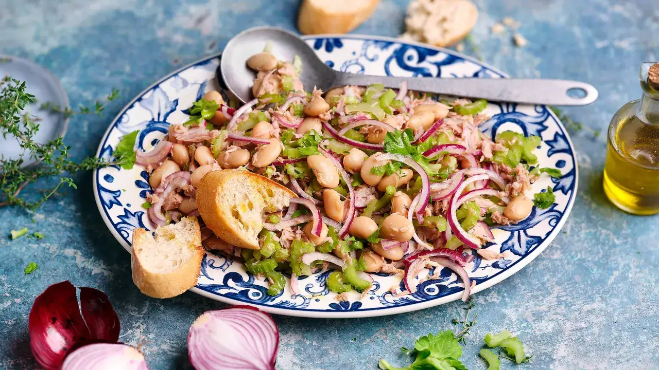 Ein herzhafter Thunfisch Bohnen Salat Italienisch mit roten Zwiebeln und Sellerie, serviert mit Brot.
