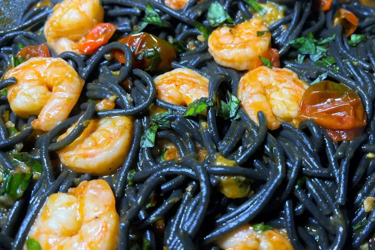 Schwarze Spaghetti mit Garnelen, Kirschtomaten und Kr&auml;utern. Ein k&ouml;stliches Gericht, das die Sinne verzaubert.