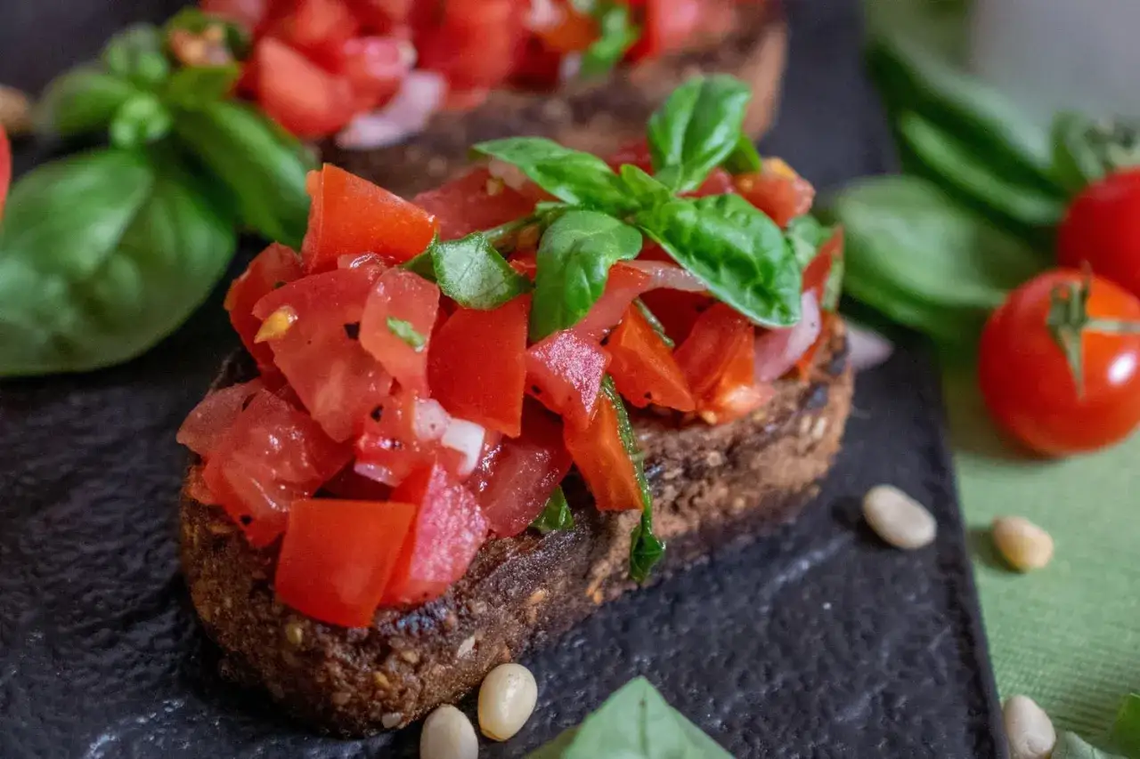 Ein köstliches rezept bruschetta original italienisch: geröstetes Brot mit frischen Tomaten, Basilikum und Pinienkernen.