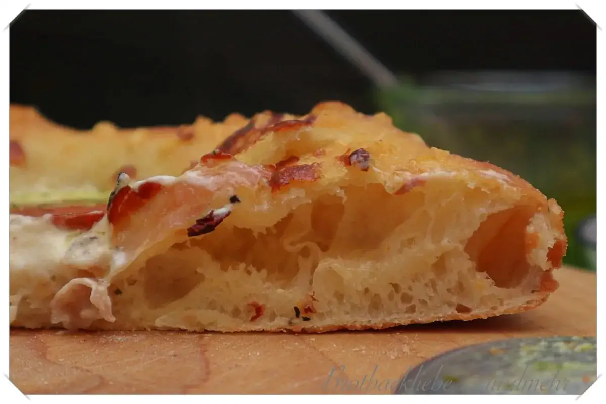 Ein Stück Pinsa mit luftigem Teig und herzhaftem Belag. Dieses Pinsa Rezept ist ein Genuss!