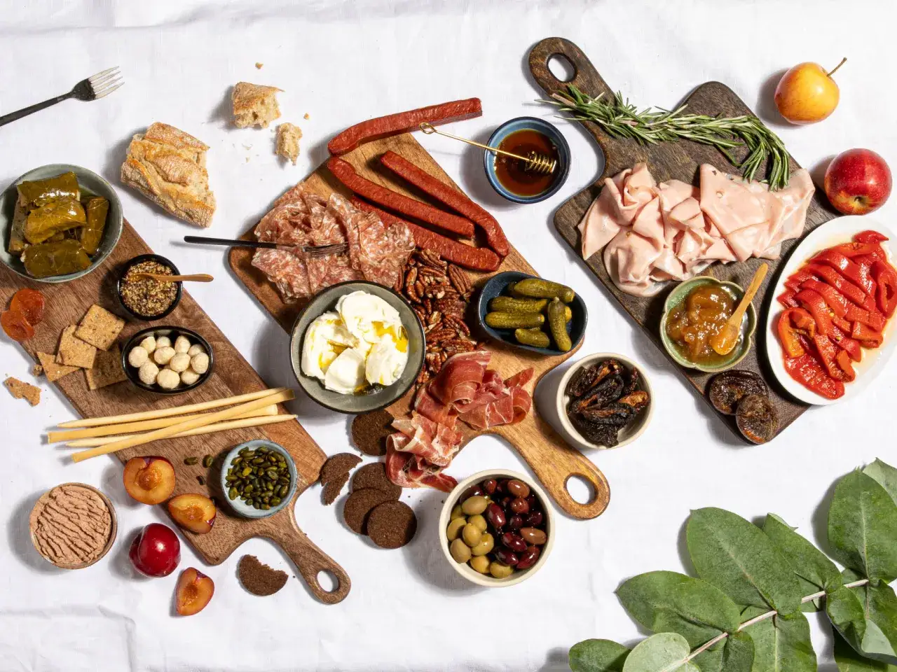 Eine reichhaltige antipasti platte mit Wurst, Käse, Oliven, Früchten und Brot.