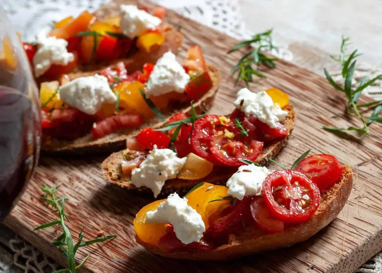Leckere Bruschetta mit bunten Tomaten und cremiger Burrata. Perfekt f&uuml;r leichte Sommergerichte und Burrata Rezepte.