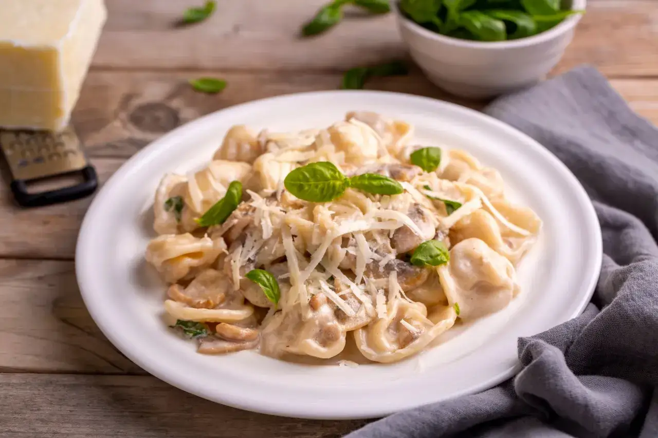 Cremige Tortellini Funghi mit frischem Basilikum und Parmesan. Ein Genuss für jeden Pasta-Liebhaber.