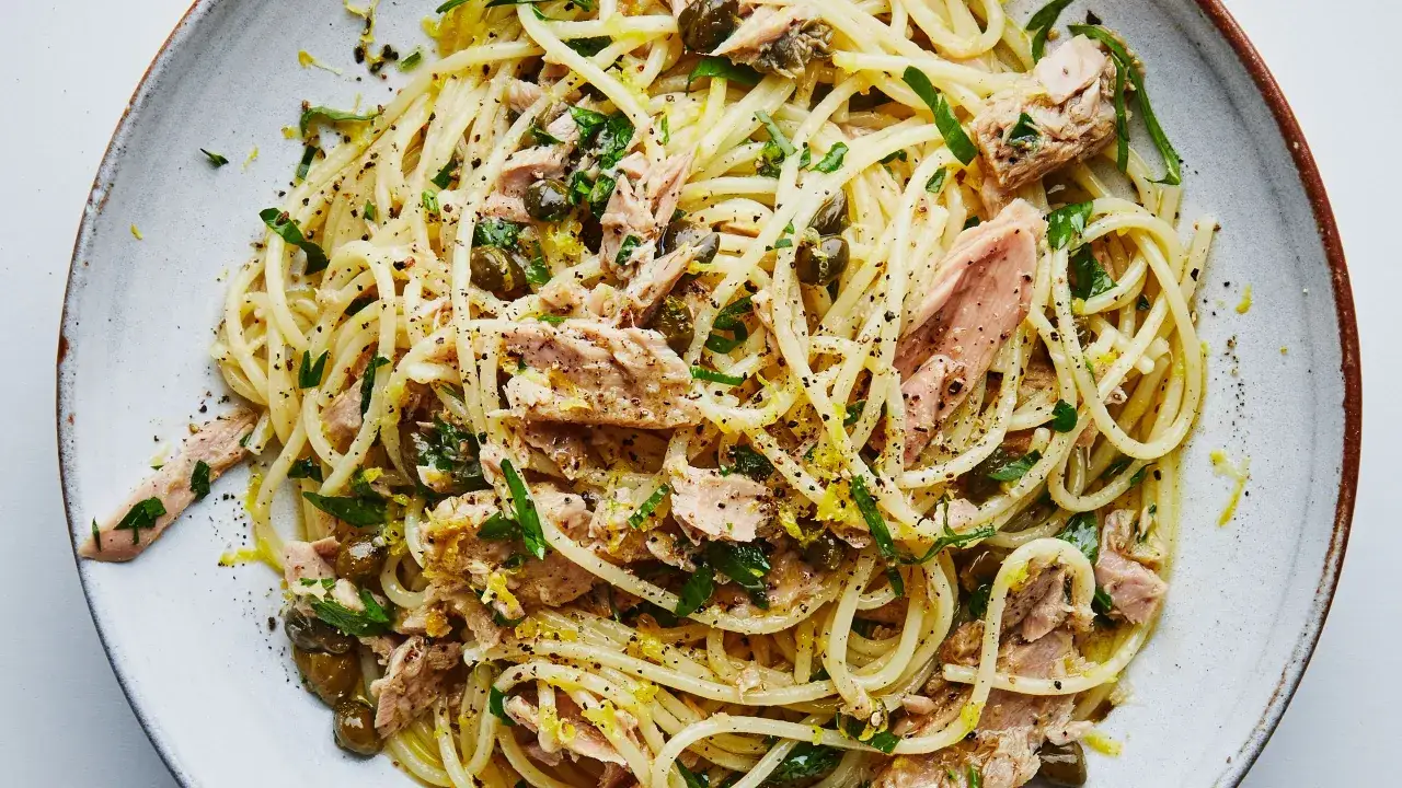 Spaghetti mit Thunfisch, Kapern und Zitrone. Ein köstliches Thunfisch Pasta Gericht, garniert mit frischer Petersilie und schwarzem Pfeffer.