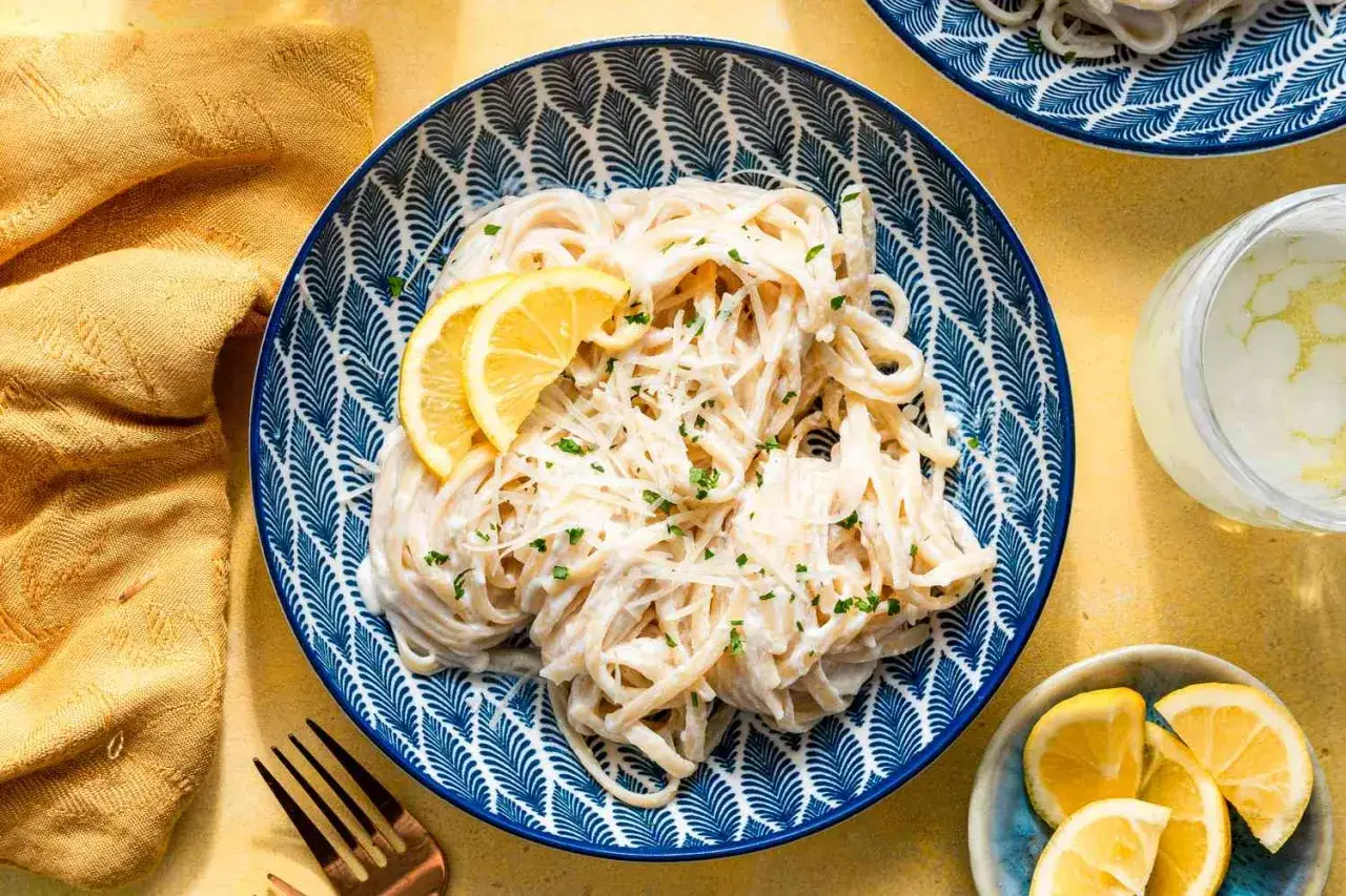 Cremige Pasta mit Zitrone, Sahne und Parmesan, garniert mit frischer Petersilie und Zitronenspalten. Ein Genuss!
