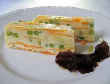 Zwei Scheiben Gemüseterrine mit Erbsen und Karotten, eine köstliche Vorspeise. Perfekt für Terrinen Rezepte.