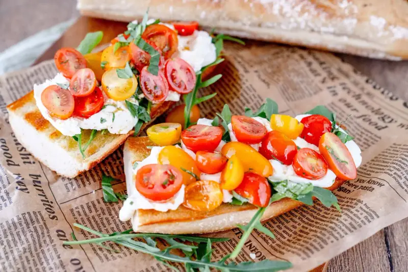 Burrata-Bruschetta mit bunten Tomaten und Rucola – ein einfaches Rezept für den Sommer.