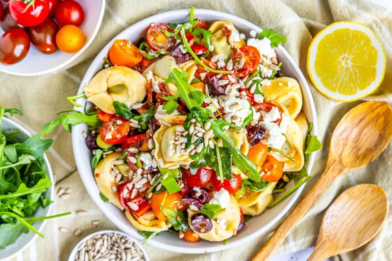 Ein bunter, sommerlicher Tortellinisalat mit Kirschtomaten, Rucola, Oliven und Feta. Perfekt für heiße Tage!