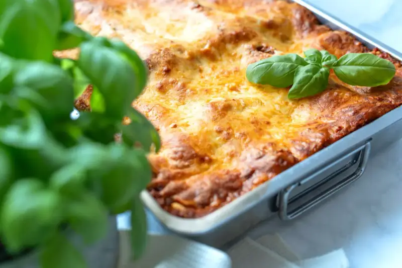 Frisch gebackene Lasagne im Ofen, goldbraun überbacken, mit frischem Basilikum garniert. Ein perfektes Lasagne Rezept für Genießer.